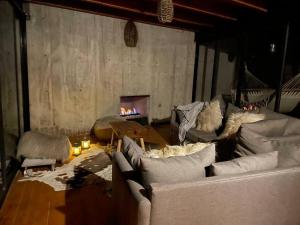 ein Wohnzimmer mit einem Sofa und einem Kamin in der Unterkunft Chalet nordico enmedio del bosque in Mineral del Monte