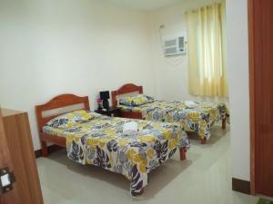 モアルボアルにあるJunie Pension Houseのベッド2台(スカートを着用した部屋内)