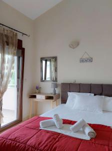 una camera da letto con un letto grande con una coperta rossa di Villa Artemis Keramoti a Keramotí Altre 33 foto