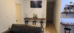 特卡特的住宿－Casa Amorosa，厨房设有带凳子的吧台,墙上配有电视