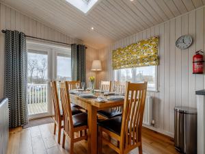 a dining room with a wooden table and chairs at Acer Lodge-uk37594 in Willington