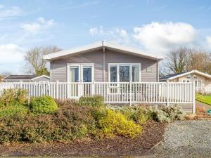 a house with a white fence in front of it at Acer Lodge-uk37594 in Willington