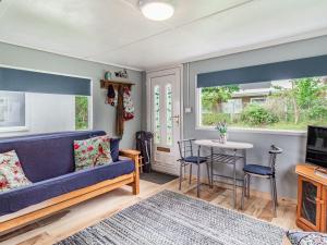a living room with a blue couch and a table at Bluebird Chalet in Mundesley