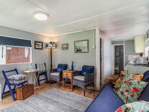 曼德斯里的住宿－Bluebird Chalet，客厅配有沙发、椅子和桌子