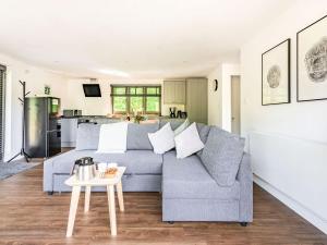 ein Wohnzimmer mit einem Sofa und einem Tisch in der Unterkunft Culver Croft in Chiddingstone