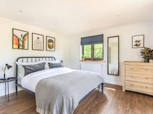a bedroom with a bed and a dresser and a window at Culver Croft in Chiddingstone