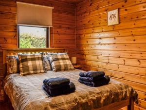 sypialnia z łóżkiem w drewnianym domku w obiekcie Tipperwhig w mieście Balintore