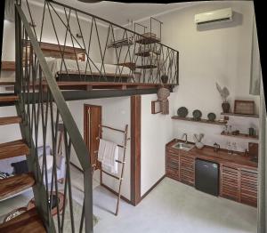 a living room with a spiral staircase and a kitchen at Hotel Boutique TerraNova in Tulum