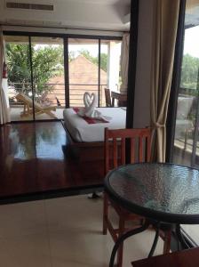 um quarto com uma cama, uma mesa e uma janela em chawenglakeviewcondo em Koh Samui 