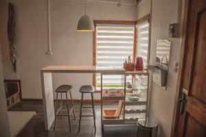 a kitchen with a counter and stools in a room at Toore Patagonia in Puerto Natales