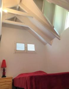 ein Schlafzimmer mit weißen Decken und einem roten Bett in der Unterkunft Villa Kabrit Bwa Sainte-Luce in Sainte-Luce