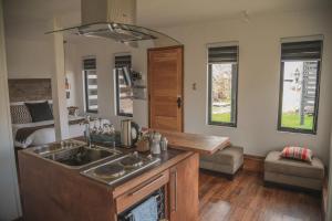 a kitchen with a sink and a bed in a room at Bungalow by Toore Patagonia in Puerto Natales