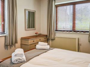 a bedroom with a bed with towels on it at The Old School in Lowick