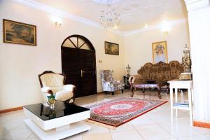 a living room with a door and chairs and a table at Plot 4 Kavuma Close in Kampala