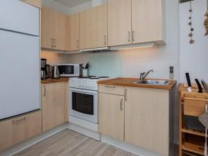 a kitchen with white appliances and wooden cabinets at 4 person holiday home in Vestervig in Vestervig