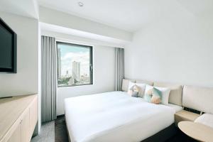 OMO3 Tokyo Akasaka by Hoshino Resort في طوكيو: غرفة نوم بيضاء مع سرير كبير ونافذة
