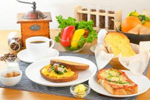 OMO3 Tokyo Akasaka by Hoshino Resort في طوكيو: طاولة مع أطباق من طعام الإفطار وكوب من القهوة