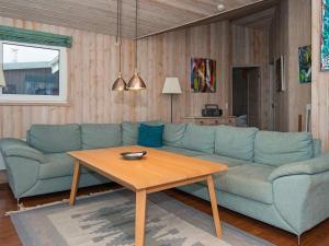 Røndeにある8 person holiday home in R ndeのリビングルーム(青いソファ、木製テーブル付)
