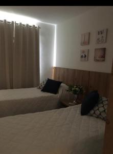 A bed or beds in a room at Guarajuba apartamento máximo 4 pessoas- 2 suítes- 170m praia