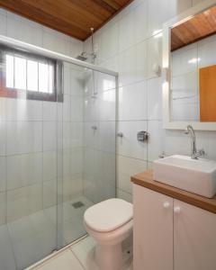 een witte badkamer met een toilet en een wastafel bij Casa de campo São Bartolomeu in Coronel Pilar