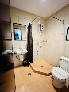 La salle de bains est pourvue de toilettes, d'un lavabo et d'une douche. dans l'établissement Coron Ecolodge, à Coron
