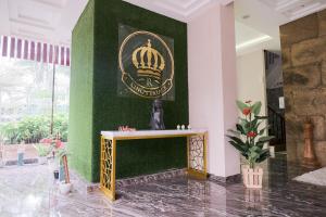 Una habitación con una pared verde con una corona de oro. en King's Palace Mitra RedDoorz, en Medan