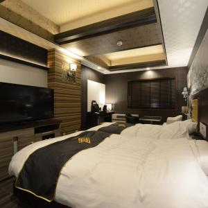 Hotels & Resort Feel في يوكوهاما: غرفة فندقية بسرير كبير وتلفزيون بشاشة مسطحة
