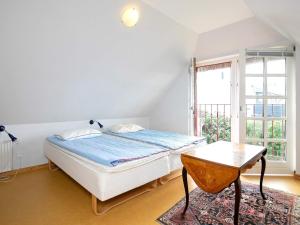 a bedroom with a bed and a table and a window at 8 person holiday home in Blokhus in Blokhus