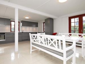 a kitchen with a white table and a white table and chairs at 8 person holiday home in Blokhus in Blokhus