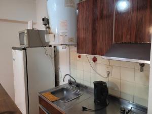 Una pequeña cocina con fregadero y refrigerador. en Edificio Independencia Lavalle 35, en Mendoza