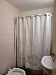 Un baño con cortina de ducha y un inodoro. en Edificio Independencia Lavalle 35, en Mendoza