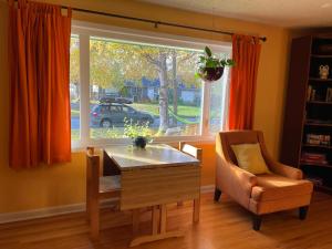 a dining room with a table and a chair and a window at Turnagain Guest House in Anchorage