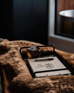 una tableta en una manta con un bolígrafo y un libro en HighTree Chalets 