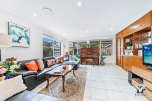 a living room with a couch and a piano at KozyGuru / Rockdale / Spacious Modern 2 Bedrooms Holiday Home NRO147 in Sydney