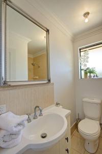 a bathroom with a sink and a toilet and a mirror at WOOD14 - River Suite in Perth