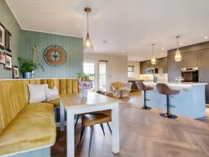 Woodhouse Lodge في بولي بريدج: مطبخ وغرفة معيشة مع طاولة وأريكة