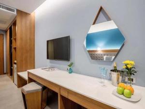 a bathroom with a sink, mirror and a television at BlueSotel Krabi AoNang Beach- SHA Extra Plus in Ao Nang Beach