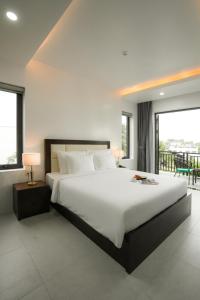 a bedroom with a large bed and a balcony at DAD Resort Phú Quốc in Phú Quốc