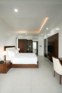 a bedroom with a large bed and a television at DAD Resort Phú Quốc in Phú Quốc