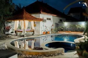 uma piscina com um gazebo ao lado de uma casa em Lovina Vibes Hotel em Balian