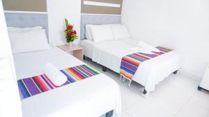 a room with two beds and a table with flowers at Hotel Playa Divina in Coveñas +34 photos