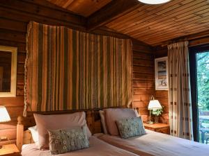 a bedroom with a bed and a wooden wall at Finlog in Bradworthy