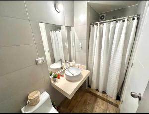 a bathroom with a sink and a toilet and a mirror at Apartamento con linda terraza in Lima