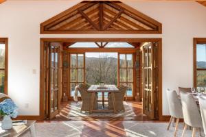 une salle à manger décloisonnée avec une table et des chaises dans l'établissement Peace-Realm Retreat, à Matakana