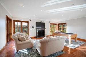a living room with two chairs and a pool table at Peace-Realm Retreat in Matakana