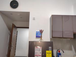 a kitchen with a refrigerator and a clock on the wall at Salcedo's Units in Baguio