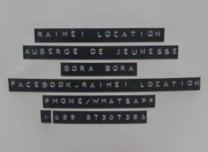 un grupo de carteles callejeros colgando de una pared en Raihei Auberge de jeunesse Chez l'habitant à Bora Bora, en Bora Bora