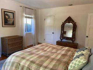 a bedroom with a bed and a dresser and a mirror at Charming Duplex with private backyard in Los Angeles