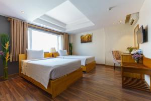 Habitación de hotel con 2 camas y escritorio en Roseland Corp Hotel, en Ho Chi Minh