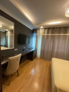 Habitación con cama y escritorio con TV. en Grand Illusyin en Shah Alam